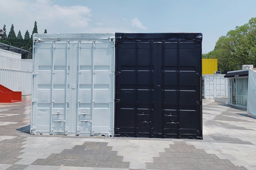 A light and dark shipping container side-by-side
