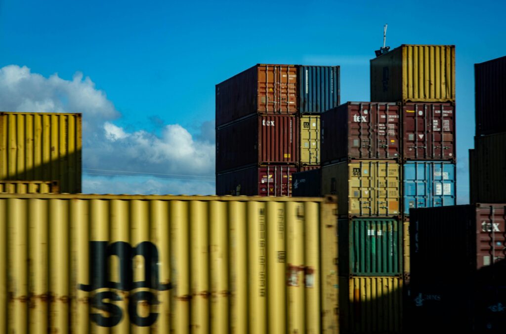 Shipping containers stacked under a clear blue sky.