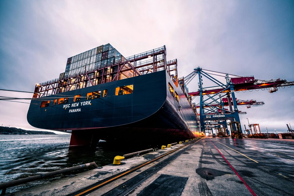 MSC New York container ship docked at a busy international port with cranes loading cargo.