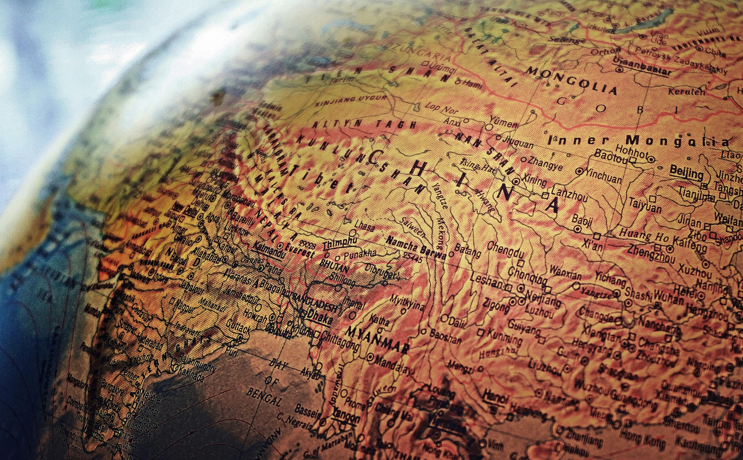 Close-up of a vintage globe highlighting China, India, and trade routes across Asia.